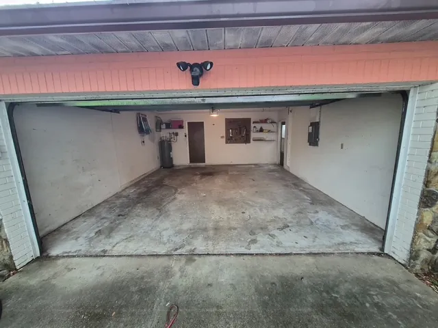 Garage floor coating before in Dunedin, FL — bare, stained concrete slab