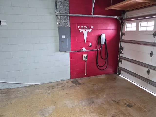 Garage floor coating before in Tampa, FL — stained slab by the Tesla charger wall